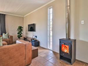 - un salon avec une cheminée et un canapé dans l'établissement Featherwood Farm & Nyala Lodge, à Rayton