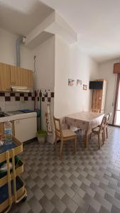 Drè Marèna في ريميني: مطبخ مع طاولة وكراسي في غرفة