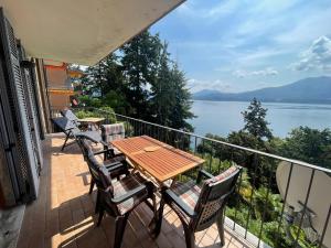 a balcony with a table and chairs and a view of the water at Gioia in Oggebbio