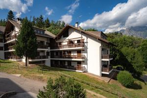 un edificio de apartamentos en las montañas con árboles en La Finestra sui Monti - Alpine Stay Apartments, en Cavalese