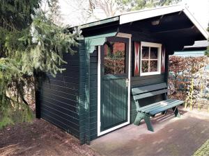 een groene schuur met een bank ervoor bij Mooie 6 persoons vakantieboerderij in de Achterhoek in Eibergen