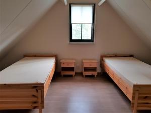 twee bedden in een kamer met een raam bij Mooie 6 persoons vakantieboerderij in de Achterhoek in Eibergen