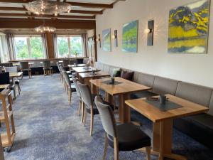 a dining room with wooden tables and chairs at Weingutshotel Piesporter Goldtröpfchen in Piesport