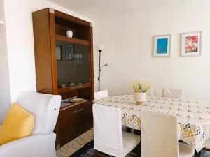 a dining room with a table and white chairs at Villa Service - Torre Barot 5º in Calafell