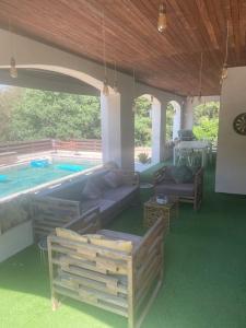 een patio met een bank en een zwembad bij Villa de charme piscine et jacuzzi 190 m2 in Mouans-Sartoux