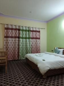 a bedroom with two beds and a window at Maryoul Guest House, Hunder Nubra in Hundar