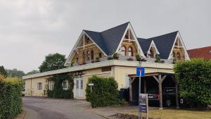 un edificio con una casa con techo de gambrel en Akzent Hotel Alte Direktionsvilla Kupfermühle, en Flensburg