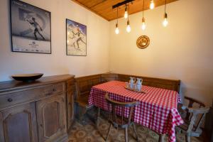 een eetkamer met een tafel met een rode en witte tafellaken bij La Finestra sui Monti - Alpine Stay Apartments in Cavalese