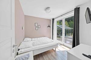 NeksøにあるBeautiful Holiday Home On A Scenic Plotのベッドと大きな窓のある白い寝室