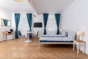a bedroom with blue curtains and a bed and a table at Downtown Sibiu in Sibiu