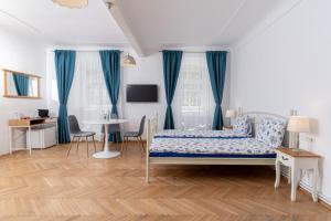 een slaapkamer met blauwe gordijnen en een bed en een tafel bij Downtown Sibiu in Sibiu
