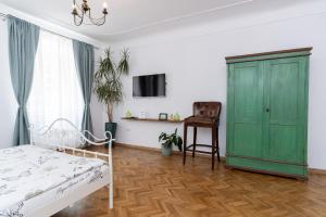 een slaapkamer met een bed en een groene kast bij Downtown Sibiu in Sibiu +25 foto's