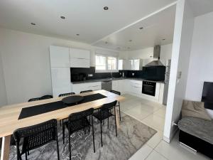 a kitchen with a wooden table and black chairs at Résidence Foch in Lingolsheim