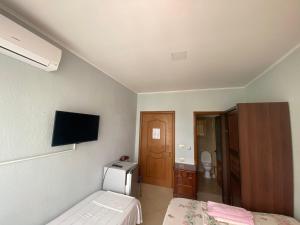 a hotel room with two beds and a television at Vila Vadeha in Pogradec