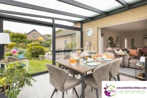 a dining room and living room with a table and chairs at B&b La Villa Orchidées, breakfast included in Bassenge