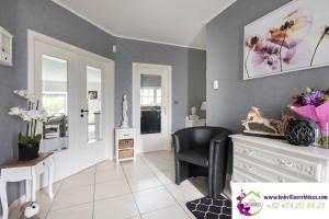 a living room with a black chair and a dresser at B&b La Villa Orchidées, breakfast included in Bassenge