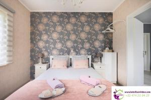 a bedroom with a bed with pink slippers on it at B&b La Villa Orchidées, breakfast included in Bassenge