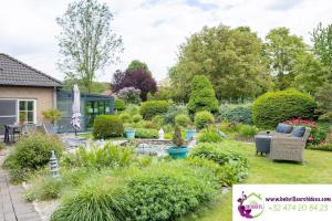 a garden with a pond and landscaping at B&b La Villa Orchidées, breakfast included in Bassenge
