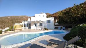 a swimming pool in front of a white house at The Sundown Villa in Parasporos