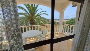 d'un balcon avec une table et un palmier. dans l'établissement Albufeira Traditional Apartments IN VILLA, à Albufeira