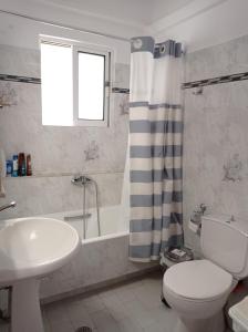 Aegean Breeze Beach House في أرتيميدا: حمام مع حوض ومرحاض وحوض استحمام