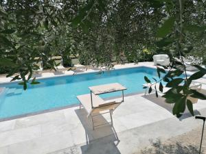 una piscina con mesa y sillas junto a ella en Hotel San Lorenzo en Pozzolengo