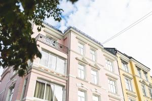 een roze gebouw met een balkon erboven bij Frogner House - Oscars gate in Oslo