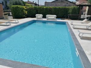 a swimming pool with two lawn chairs next to it at Hotel San Lorenzo in Pozzolengo