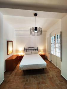 um quarto com uma cama e duas mesas de cabeceira e dois candeeiros em Casa SANTA MARÍA em Carmona