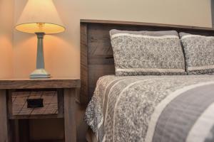 a bedroom with a bed with a lamp on a table at Adirondack Sunrise Lodge in Lake George