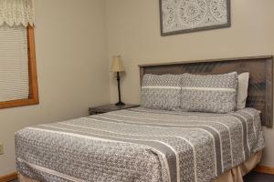 a bedroom with a bed with a blanket on it at Adirondack Sunrise Lodge in Lake George