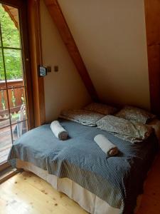 1 dormitorio con cama con almohadas y ventana en Szczyrkowskie Historie en Szczyrk