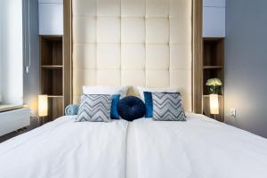ソポトにあるElite Apartments Sopot Premiumのベッドルーム(白いベッド、青い枕付)