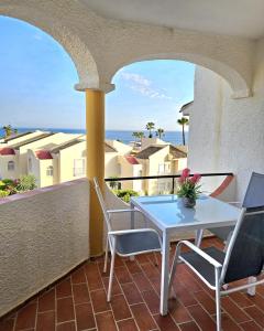 a table and chairs on a balcony with a view of the ocean at Apartamento SEA VIEW Celeste Costa del sol Playa Chapparal in Mijas Costa