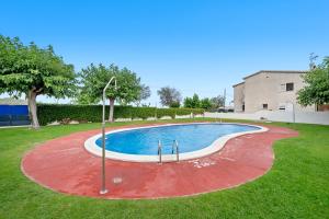 einen Pool im Garten mit einem roten und weißen in der Unterkunft Odet in Torredembarra