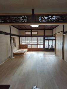 a room with a large room with wooden floors and windows at ひろの家 in Fukuchiyama