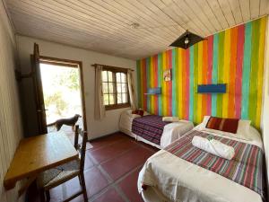 a room with two beds and a table and a window at Lipi House Hostel in Capilla del Monte