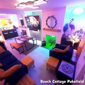 a living room with a blue couch and a table at Beach Cottage Pakefield- Newly Fully Renovated House in Pakefield