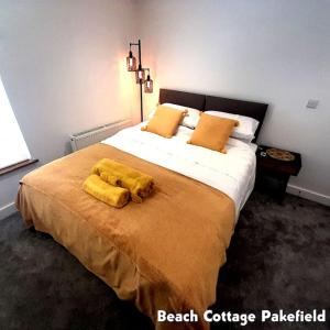 a bedroom with a large bed with yellow sheets at Beach Cottage Pakefield- Newly Fully Renovated House in Pakefield