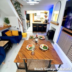 a living room with a table with plates of food on it at Beach Cottage Pakefield- Newly Fully Renovated House in Pakefield +32 photos