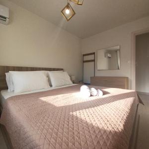 a bedroom with a bed with two white stuffed animals on it at Ionian Avra Apartment in Athanion