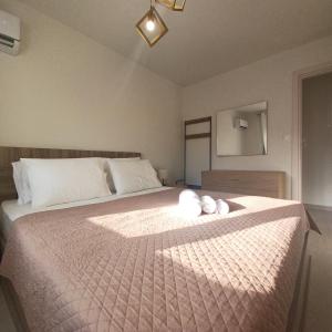 a bedroom with a bed with two white stuffed animals on it at Ionian Avra Apartment in Athani