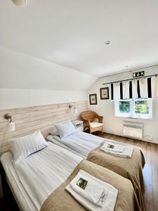 1 dormitorio con 2 camas y ventana en STF Korrö B&B en Linneryd