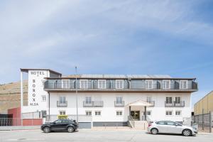 two cars parked in front of a building at Hotel Alda Borox in Borox