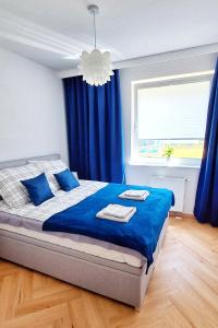 Schlafzimmer mit einem Bett mit blauer Bettwäsche und einem Fenster in der Unterkunft Blue Amber in Rumia