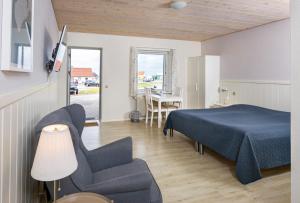 1 dormitorio con 1 cama, 1 silla y 1 mesa en Hvalpsund Færgekro, en Hvalpsund