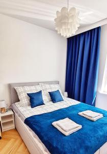 a bedroom with blue curtains and a bed with towels on it at Blue Amber in Rumia