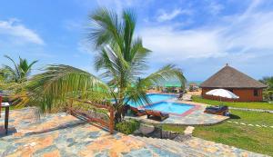 a resort with a swimming pool and a palm tree at Lemon Beach Resort in Elmina