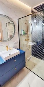 a bathroom with a sink and a shower with a mirror at Blue Amber in Rumia