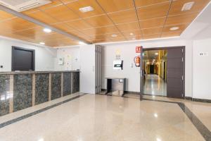 a hallway in a building with a elevator and a television at Hotel Alda Borox in Borox